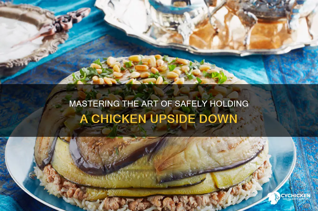 how to hold a chicken upside down